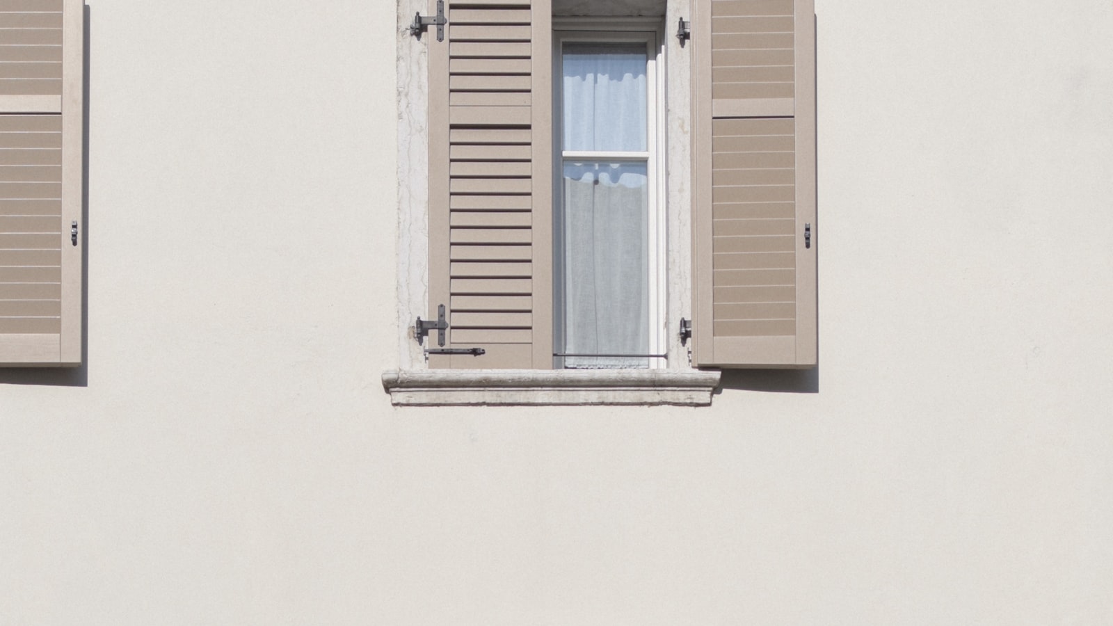 Protection solaire exterieure a lames posee en facade au-dessus d'une baie vitree