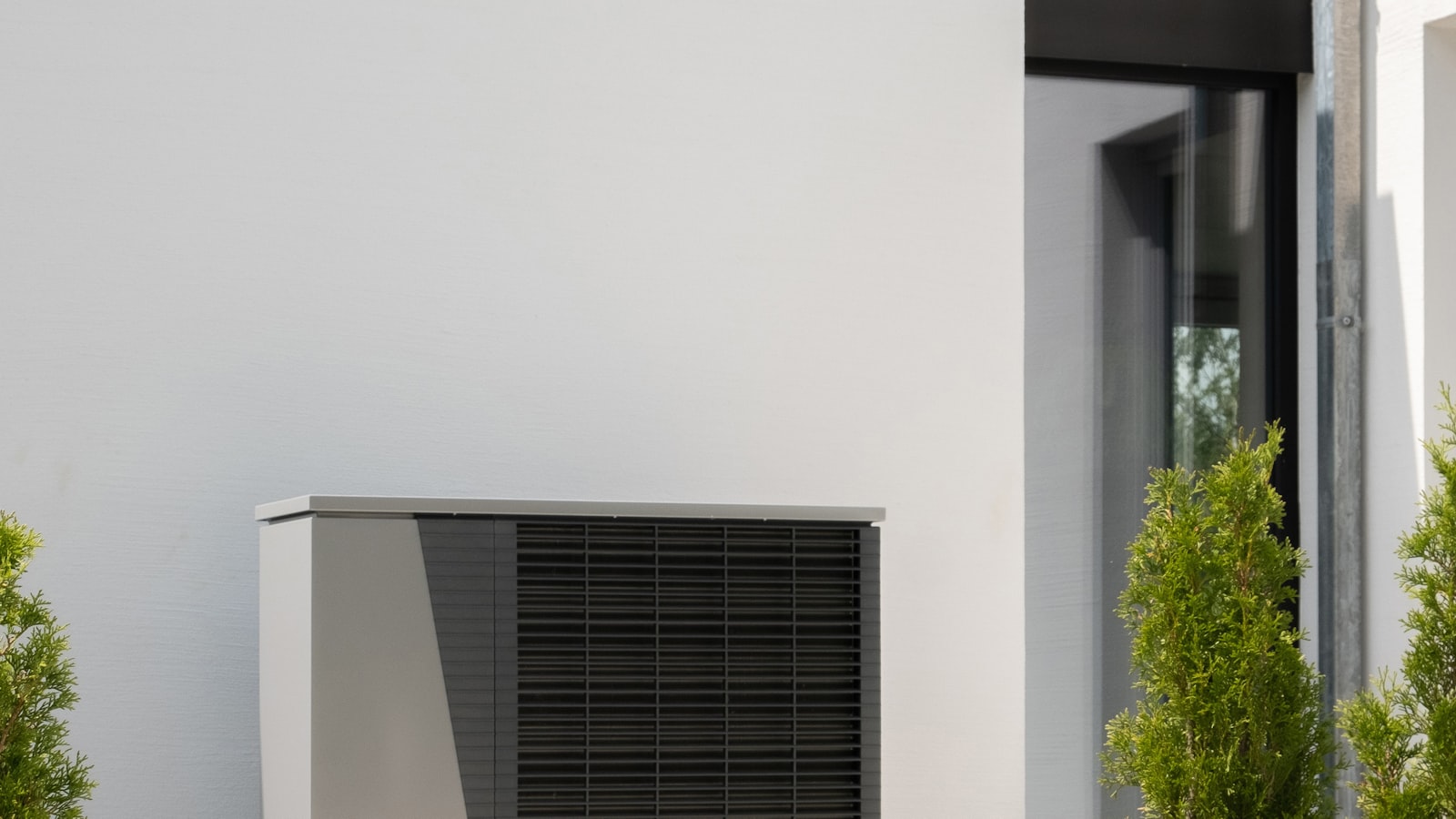 Unité extérieure d'une pompe à chaleur air-eau au propane R290 installée le long d'une maison moderne