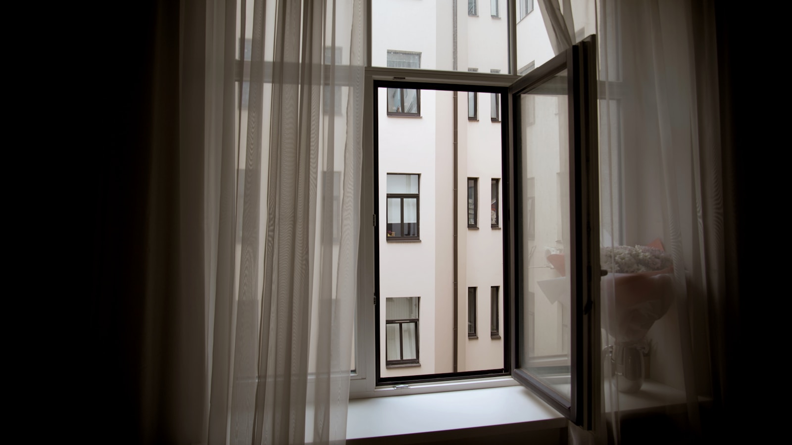 Rideaux thermiques et film solaire sur une fenêtre d'appartement exposée au soleil