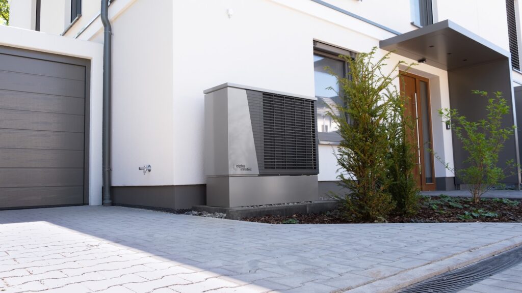 Ballon thermodynamique installé dans un garage à côté d'une pompe à chaleur