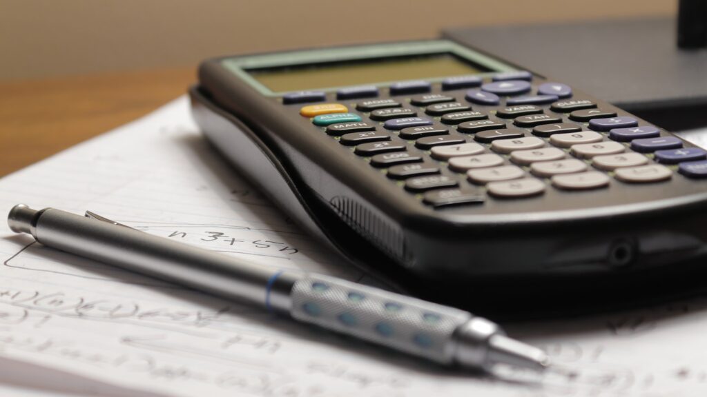 Devis de rénovation posé sur une table de cuisine à côté d'une calculatrice et d'un stylo