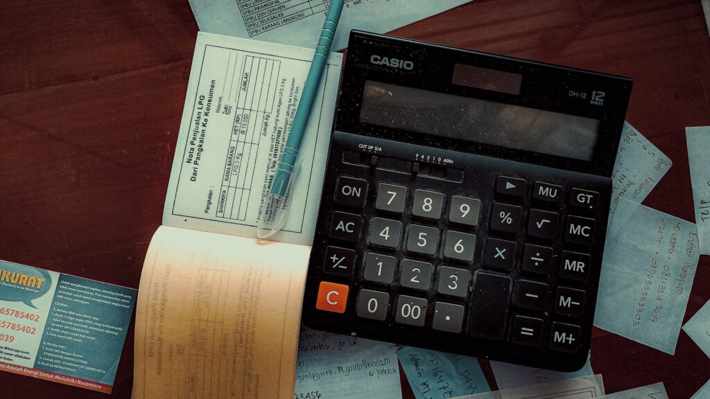Facture et calculatrice posees sur une table de cuisine