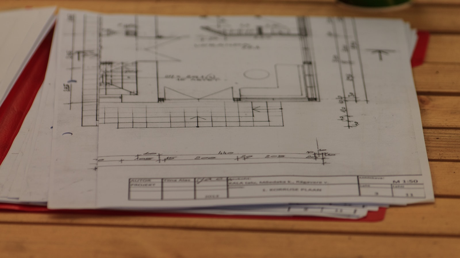 Plans d'architecte d'une maison individuelle poses sur une table de travail