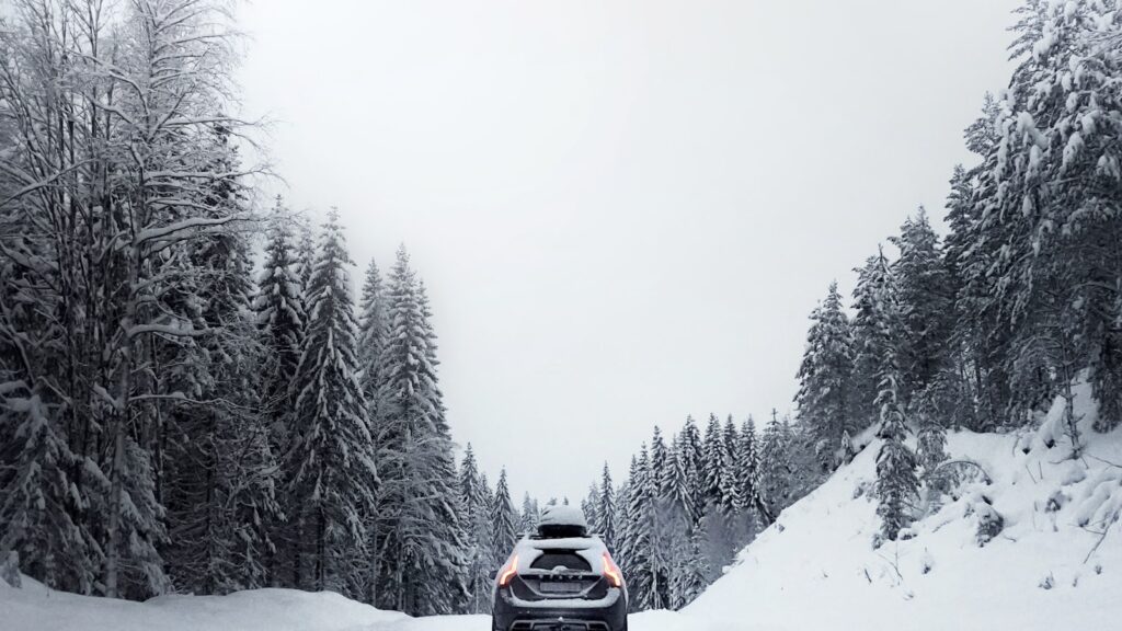 Voiture sur une route enneigee en zone de montagne