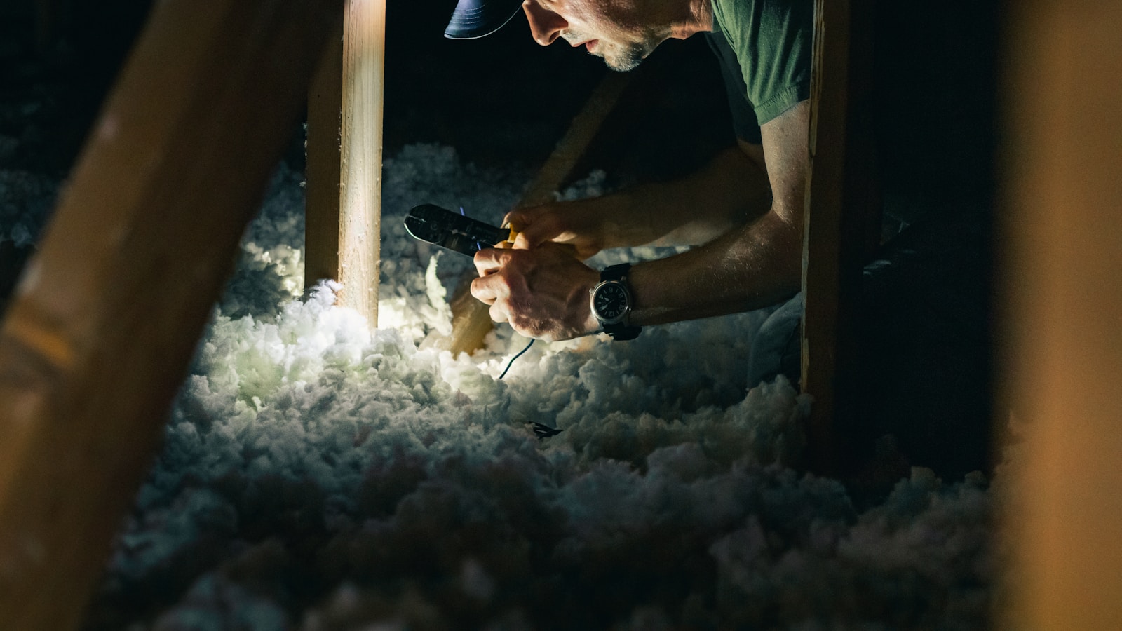 Artisan isolant des combles avant l'installation d'une pompe à chaleur