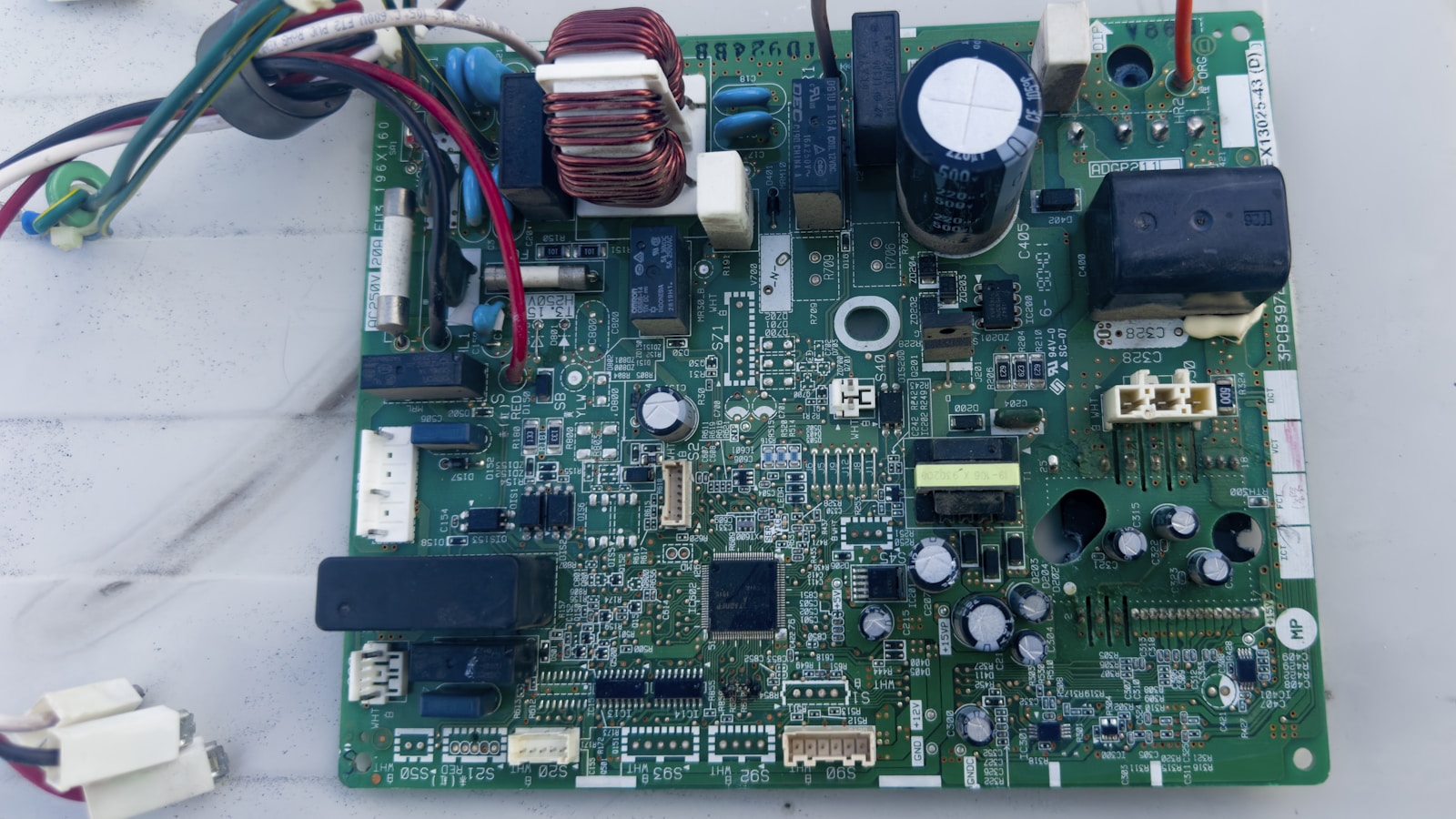 Technicien remplaçant une carte électronique sur l'unité extérieure d'une pompe à chaleur